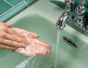 [Translate to English:] någon tvättar sina händer i ett handfat